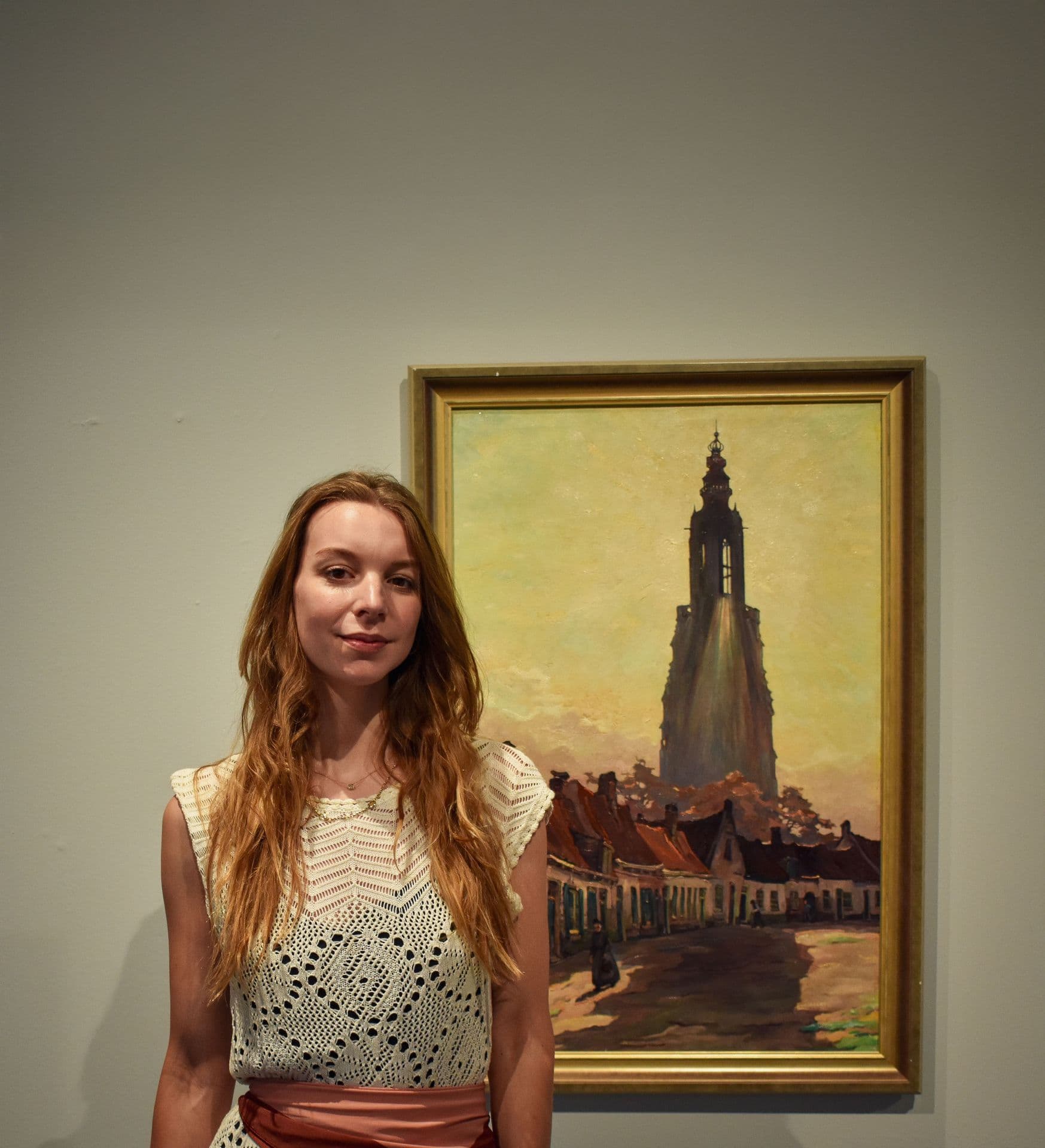 Op deze afbeelding zie je: Een persfoto van Dorine die bij een schilderij staat van Amersfoort. Deze foto is gemaakt door Vana Fotografie